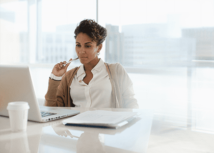 Woman considering the informatino she is reading onher computer